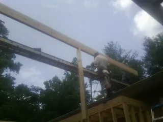 Carpenter setting a ridge beam over a new addition frame — Ice Dam Removal by Roofing Brothers in Berryton