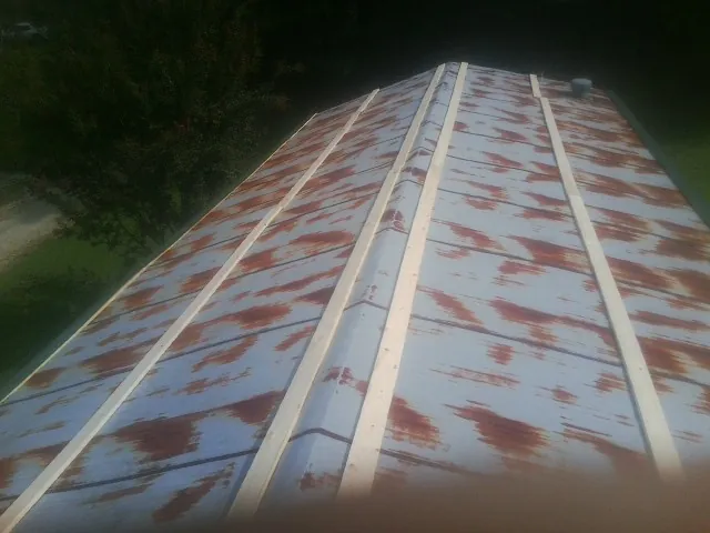 Rusted metal roof panels with new wood purlins before replacement — Storm Damage Roof Repair in Berryton by Roofing Brothers