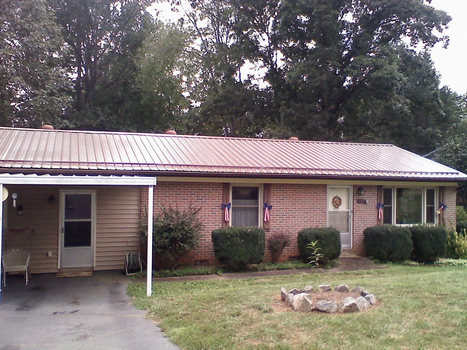 Bronze metal roof and carport on a brick ranch home — Roof Repair work by our crew in Berryton