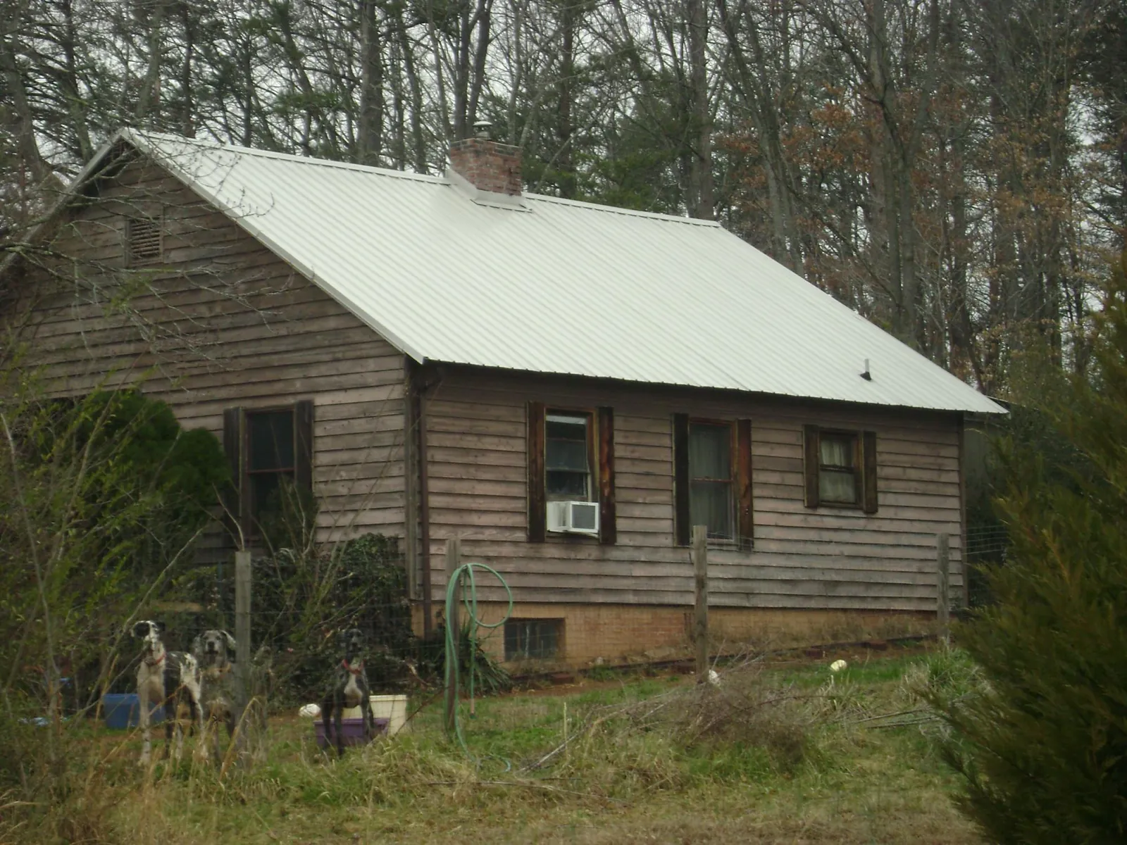 White metal roof on an old wood sided farmhouse, from a Metal Roof Installation job in Berryton